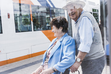 Deutschland, Mannheim, glückliches älteres Ehepaar mit Rollator wartet am Bahnhof - UUF008079