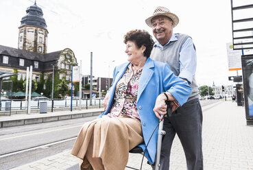 Deutschland, Mannheim, glückliches älteres Ehepaar mit Rollator wartet am Bahnhof - UUF008080