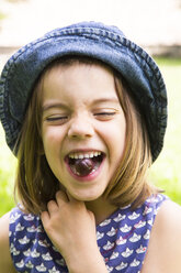 Porträt eines kleinen Mädchens mit Stachelbeere im Mund - LVF005115