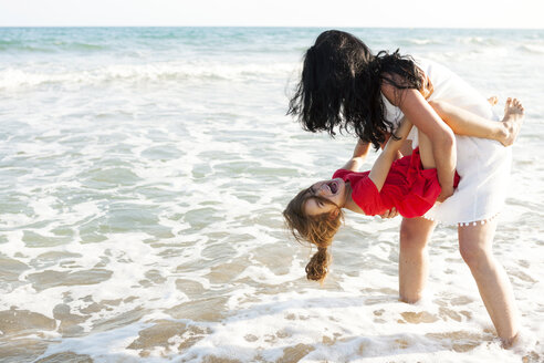 Mother playing with her little daughter at seafront - VABF000688