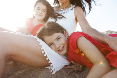 Porträt eines kleinen Mädchens zusammen mit Mutter und Schwester am Strand - VABF000692