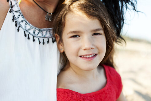Porträt eines lächelnden kleinen Mädchens neben ihrer Mutter am Strand - VABF000695