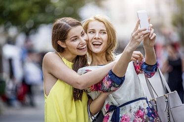 Two happy young women taking a selfie in the city - GDF001053
