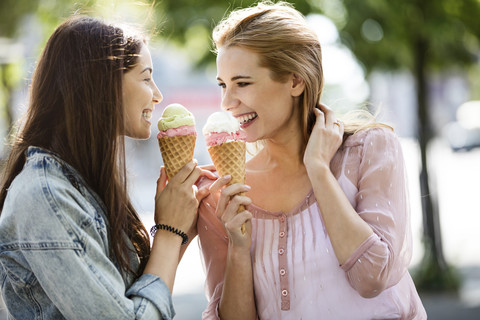 Zwei lächelnde junge Frauen mit Eiswaffeln, lizenzfreies Stockfoto