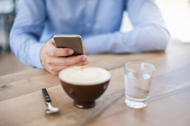 Hand of man holding smartphone, close-up - DIGF000568