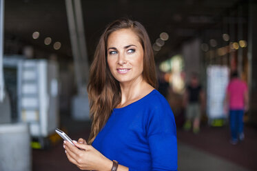 Brünette Frau hält Mobiltelefon - DIGF000587