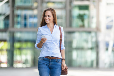 Smiling woman with cell phone outdoors - DIGF000622