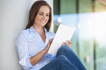 Smiling brunette woman using digital tablet - DIGF000627