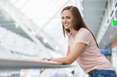 Portrait of smiling brunette woman leaning on railing - DIGF000638