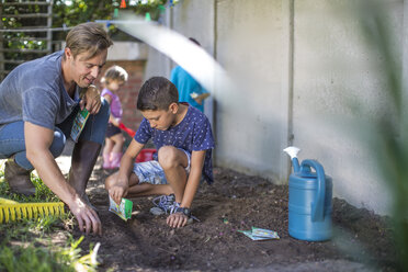 Vater und Sohn arbeiten gemeinsam im Garten - ZEF008995