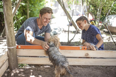 Vater und Sohn mit Hund im Garten - ZEF009002