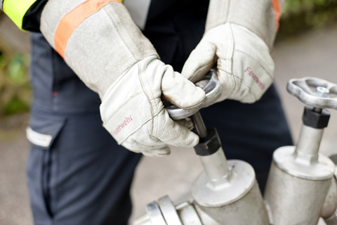 Nahaufnahme eines Feuerwehrmanns beim Öffnen eines Hydranten, lizenzfreies Stockfoto