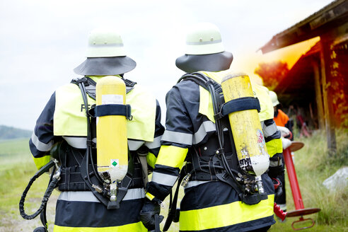 Rückansicht von zwei Feuerwehrleuten - MAEF011875