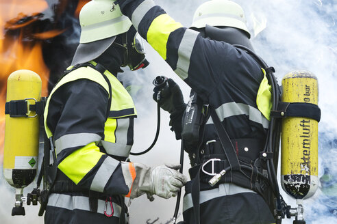 Zwei Feuerwehrleute bereiten einen Einsatz vor - MAEF011876