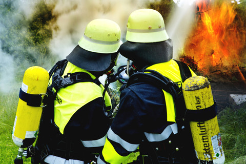 Feuerwehr beim Löschen eines Brandes, lizenzfreies Stockfoto