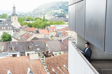 Businessman looking at documents above the city - DIGF000667