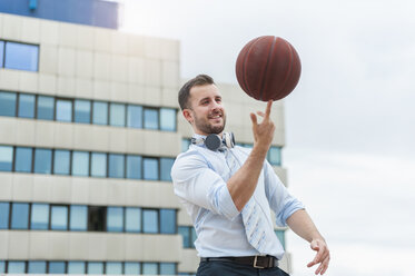 Businessman playing basketball outdoors - DIGF000672