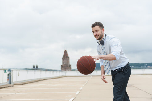 Geschäftsmann spielt Basketball im Freien - DIGF000673