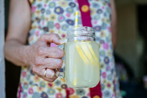 Nahaufnahme einer Frau, die ein Glas Limonade hält - KIJF000588