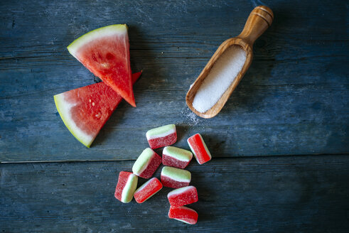 Wassermelone und Bonbons auf blauem Holz - KIJF000590