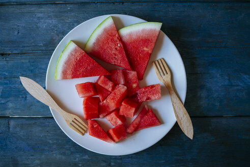 Teller mit Wassermelone, geschnitten auf blauem Holz - KIJF000591