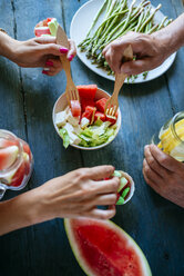 Nahaufnahme von Händen, die Salat, Wassermelone, Limonade, Spargel und Bonbons essen - KIJF000596