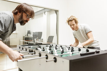 Colleagues playing table football in office - PESF000201