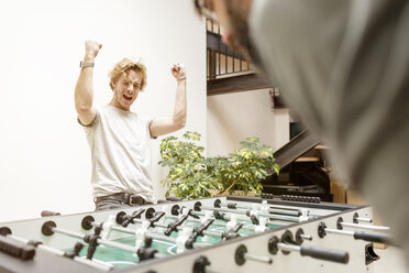 Colleagues playing table football in office - PESF000202