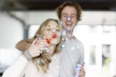 Young couple blowing soap bubbles - PESF000213