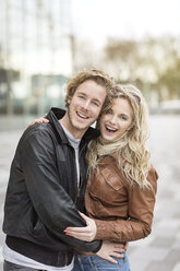 Laughing young couple embracing in city - PESF000221