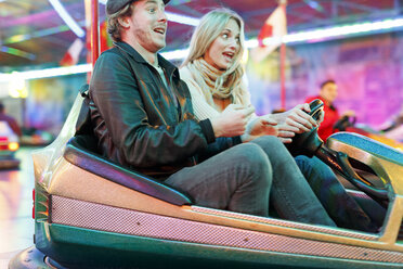 Young couple at fun fair riding bumper car - PES000225