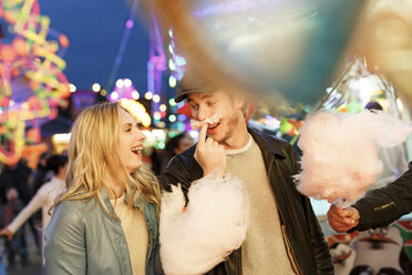 Young couple at fun fair eating candy floss - PES000226