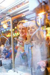 Junges Paar auf dem Jahrmarkt betrachtet die Preise im Fenster - PES000233