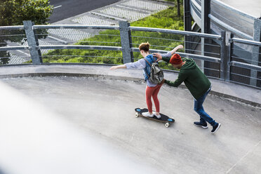 Junges Paar mit Skateboard im Parkhaus - UUF008098