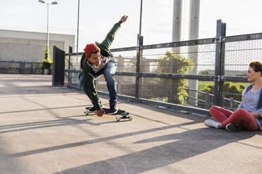 Junges Paar mit Skateboard auf Parkdeck - UUF008103