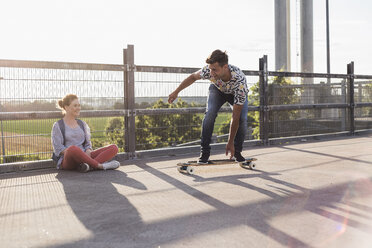 Junges Paar mit Skateboard auf Parkdeck - UUF008104