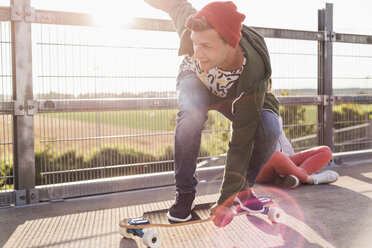 Young man riding skateboard on parking level - UUF008107