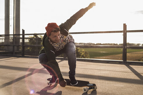 Junger Mann fährt Skateboard auf einem Parkdeck - UUF008108