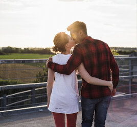 Young couple kissing at sunset - UUF008123