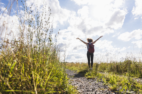 Enthusiastische junge Frau auf dem Feldweg, lizenzfreies Stockfoto