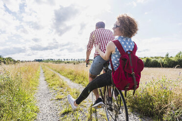 Glückliches junges Paar auf einer Fahrradtour - UUF008143