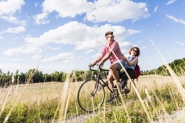 Glückliches junges Paar auf einer Fahrradtour - UUF008145