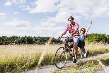 Glückliches junges Paar auf einer Fahrradtour - UUF008146