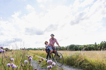 Glückliches junges Paar auf einer Fahrradtour - UUF008147