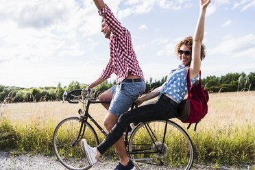 Glückliches junges Paar auf einer Fahrradtour - UUF008148