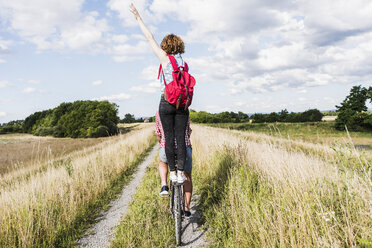 Young woman standing on bicycle rack - UUF008149