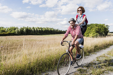 Glückliches junges Paar auf einer Fahrradtour - UUF008150