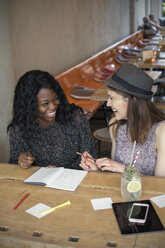 Zwei junge Frauen lernen gemeinsam in einem Café - ONF000936