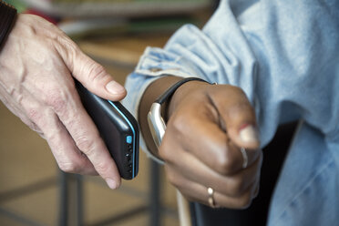 Frau bezahlt mit Smartwatch und NFC-Lesegerät - ONF000943