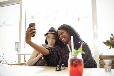 Zwei junge Frauen machen ein Selfie in einem Cafe - ONF000965